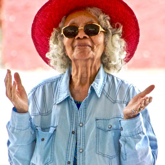 Elderly woman with red sun hat, looking slightly confused. Many people are similarly confused about Myrbetriq, a treatment option for overactive bladder.