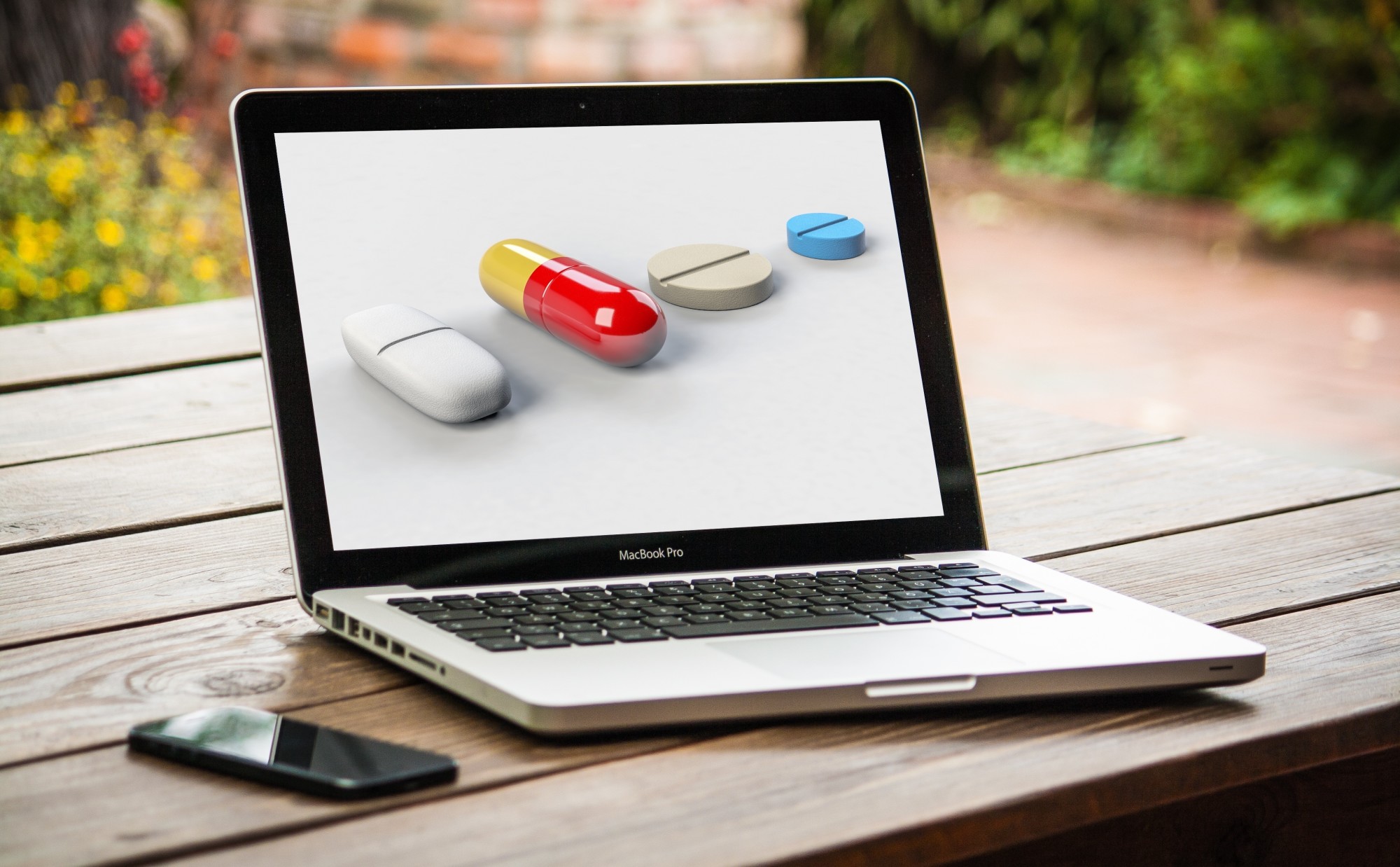 Laptop computer on table, shows different options for buying prescription drugs online.